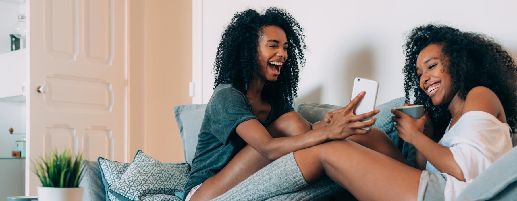 friends sitting on a couch and laughing